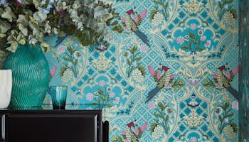 Bold bird-print blue wallpaper with table and vase